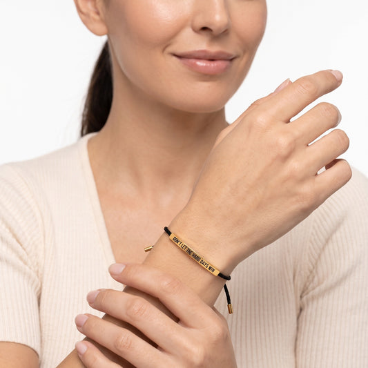 Woman wearing the Hard Days bracelet, gold bar engraved Don't Let The Hard Days Win