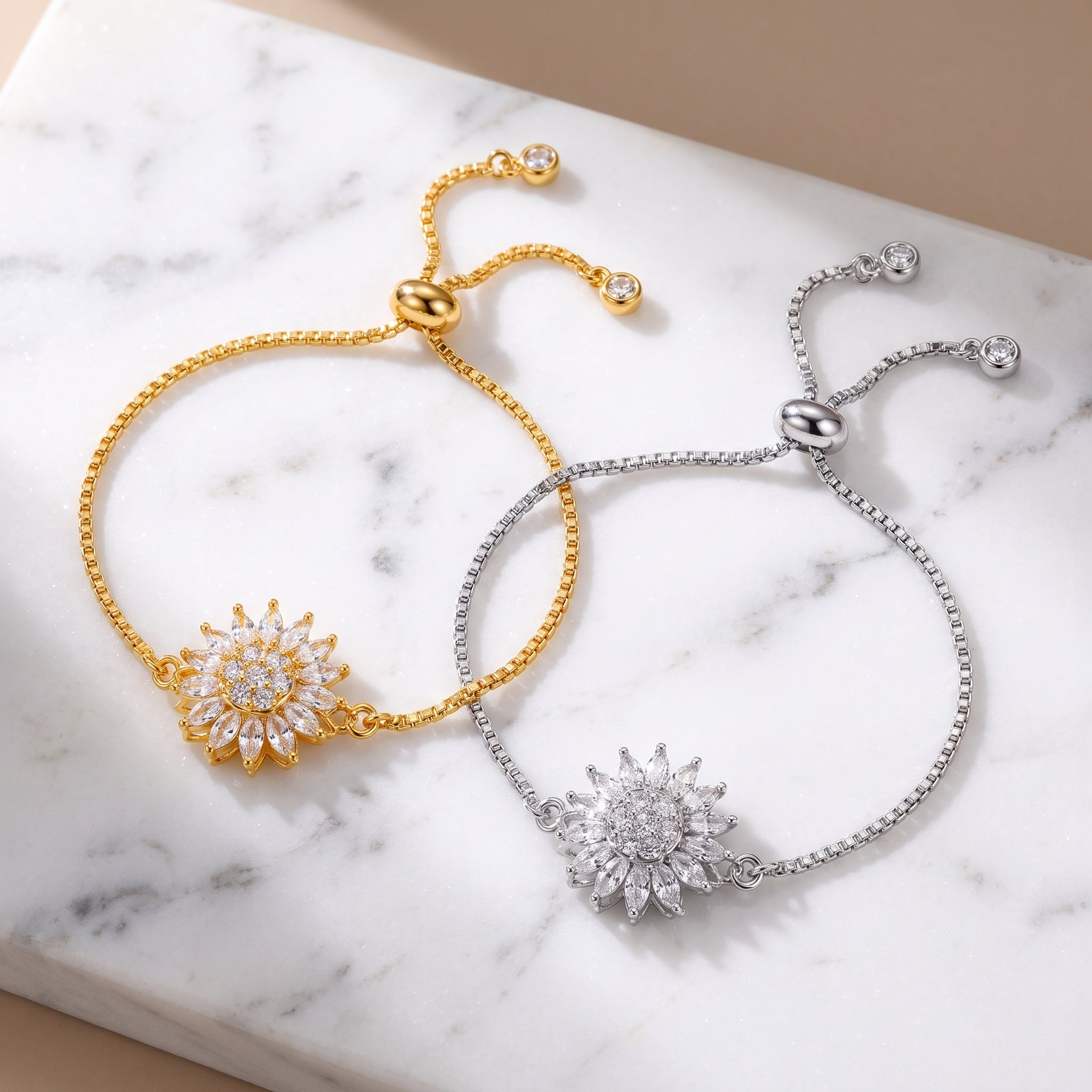 Gold and silver sunflower spinning bracelets on marble