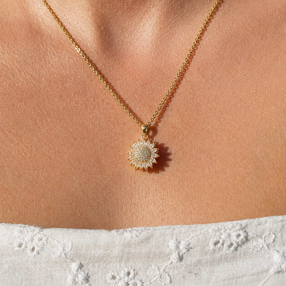 Gold sunflower pendant worn on the neckline