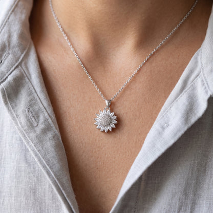 Silver sunflower spinning pendant worn on the neckline