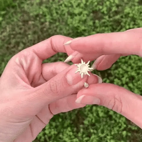 Fingers spinning the sun charm of the ring