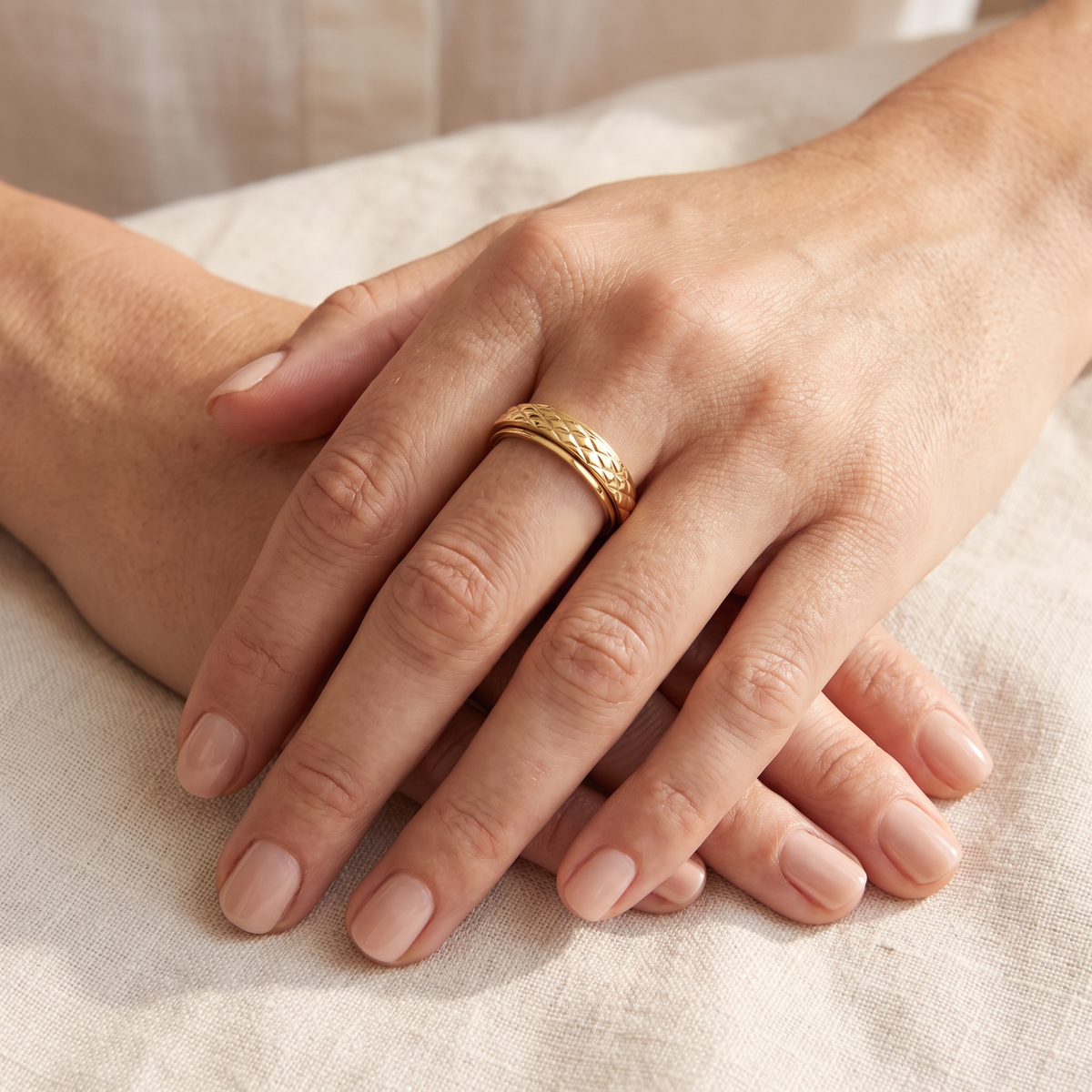 Gold Cross Pattern Spinning Ring worn on the index finger