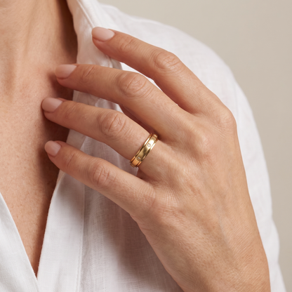 Hand at the collarbone wearing the Gold Star Spinning Ring