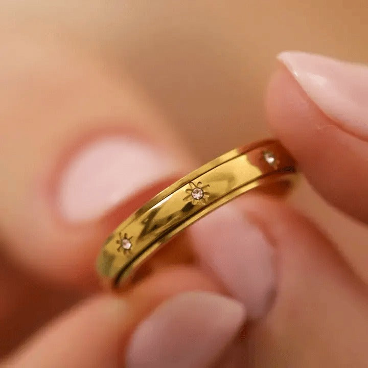 Fingers turning the gold star spinning ring