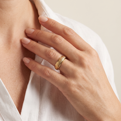 Hand at the collarbone wearing the Gold Woven Spinning Ring