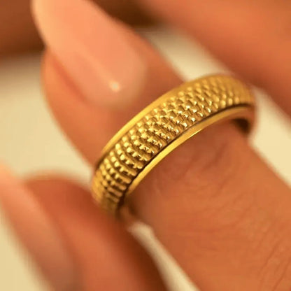 Fingers turning the gold woven spinning ring