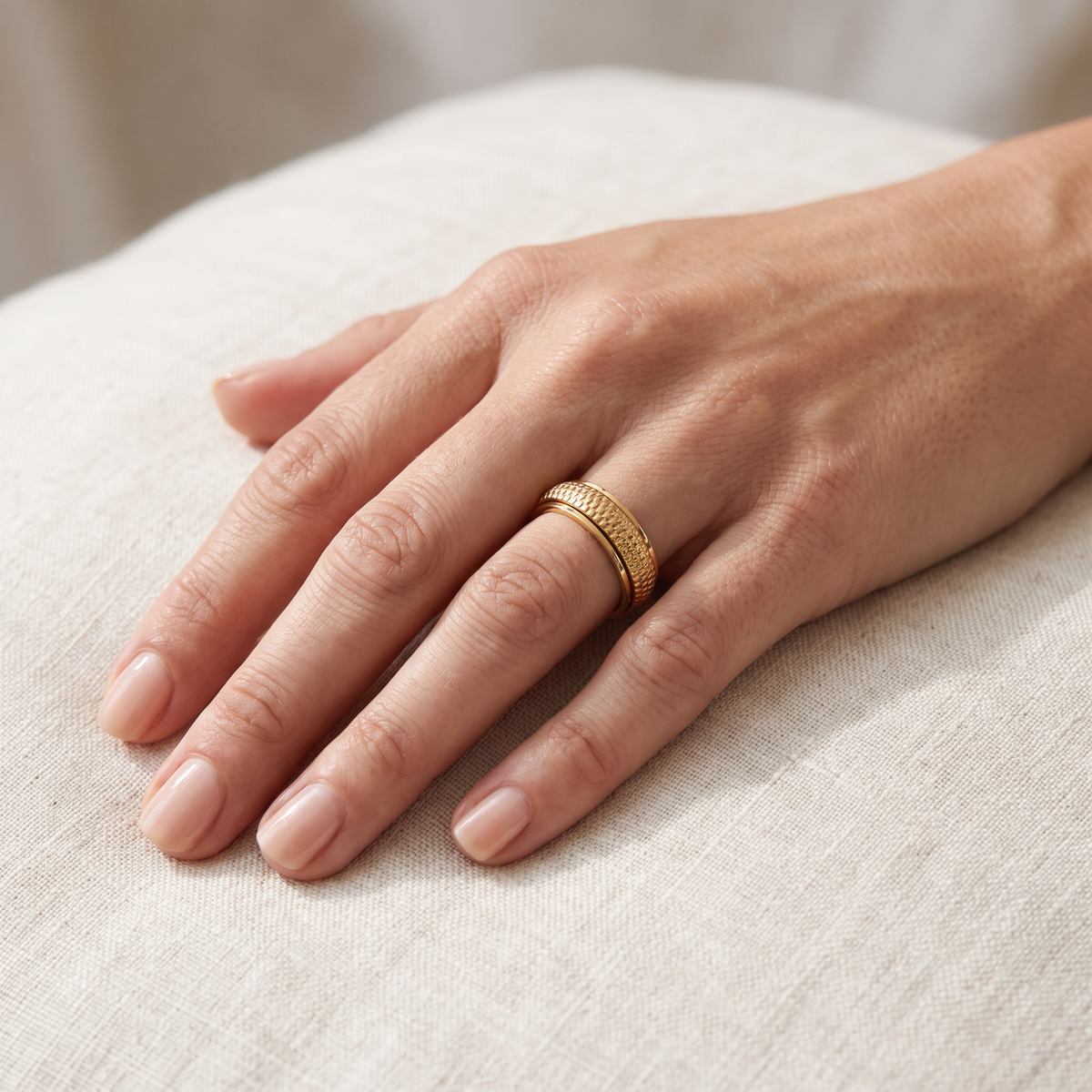 Gold Woven Spinning Ring worn on the index finger
