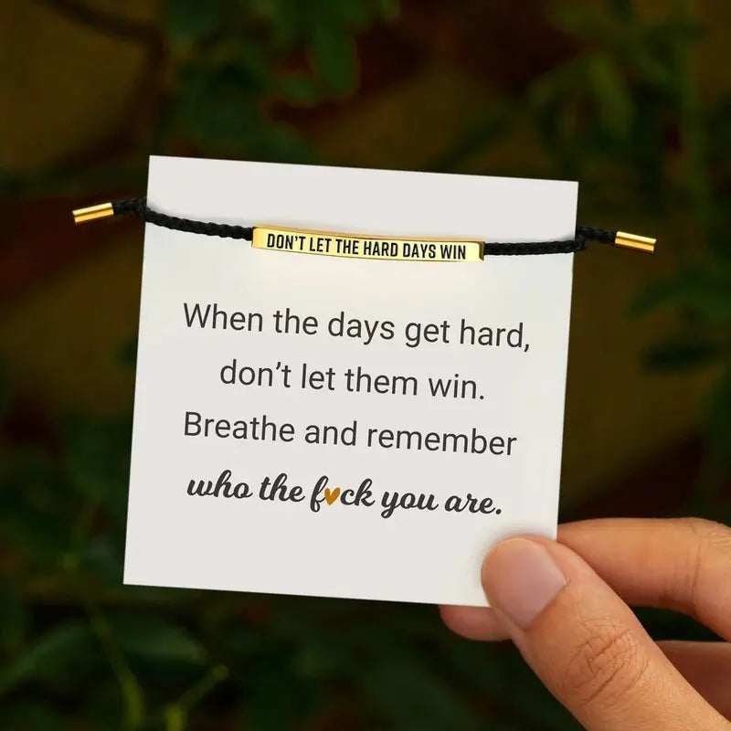 Black and gold Don't Let The Hard Days Win bracelet on its message card