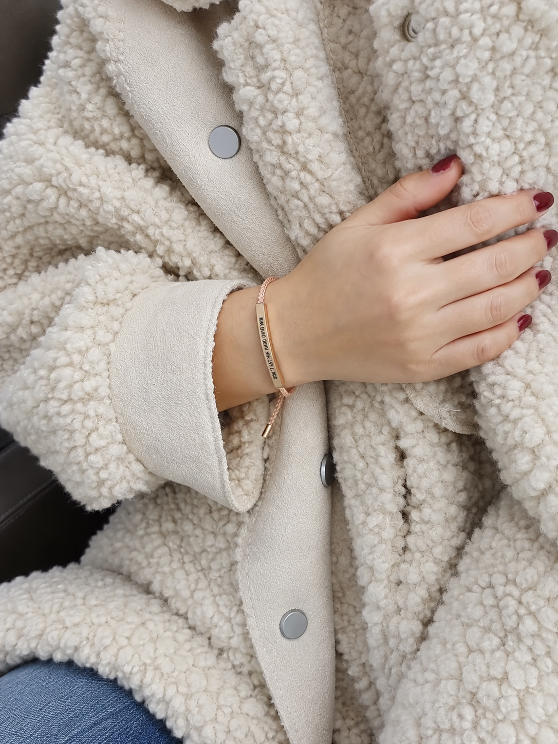 Rose gold engraved bracelet worn with a cozy coat