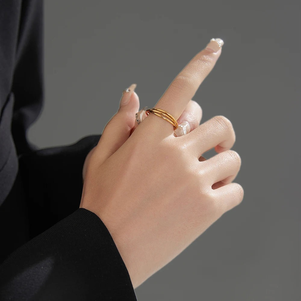 Gold triple ring worn on the index finger