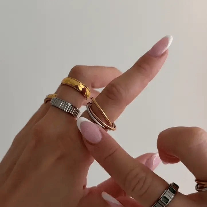 Finger rolling the three bands of the ring, stacked with other rings