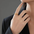 Hand wearing the gold braided rolling ring