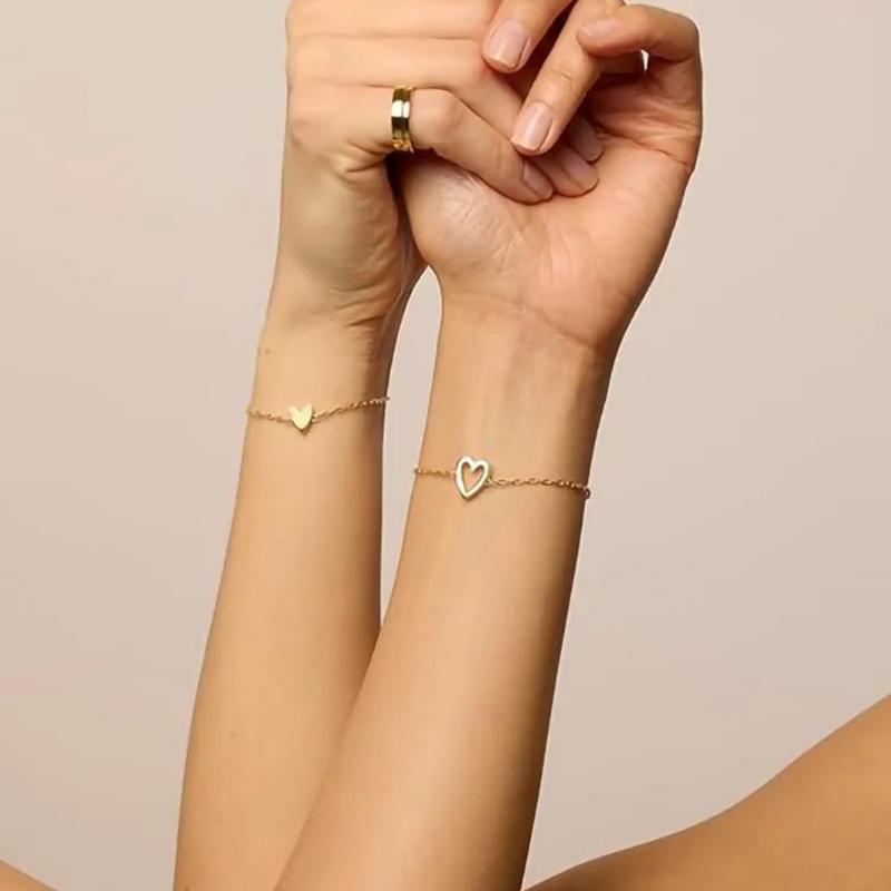 Matching heart bracelets on two wrists
