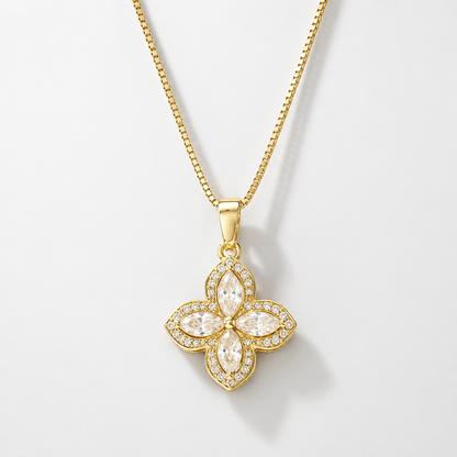 Gold four-petal flower pendant with clear crystals on a box chain