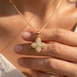 Hand holding the gold flower pendant
