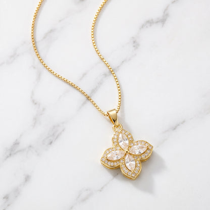 Gold flower pendant necklace on white marble
