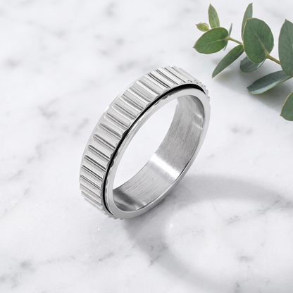 Silver Grooved Spinning Ring on white marble with eucalyptus