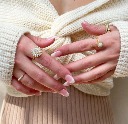 Sunflower spinner ring worn with a cream knit sweater