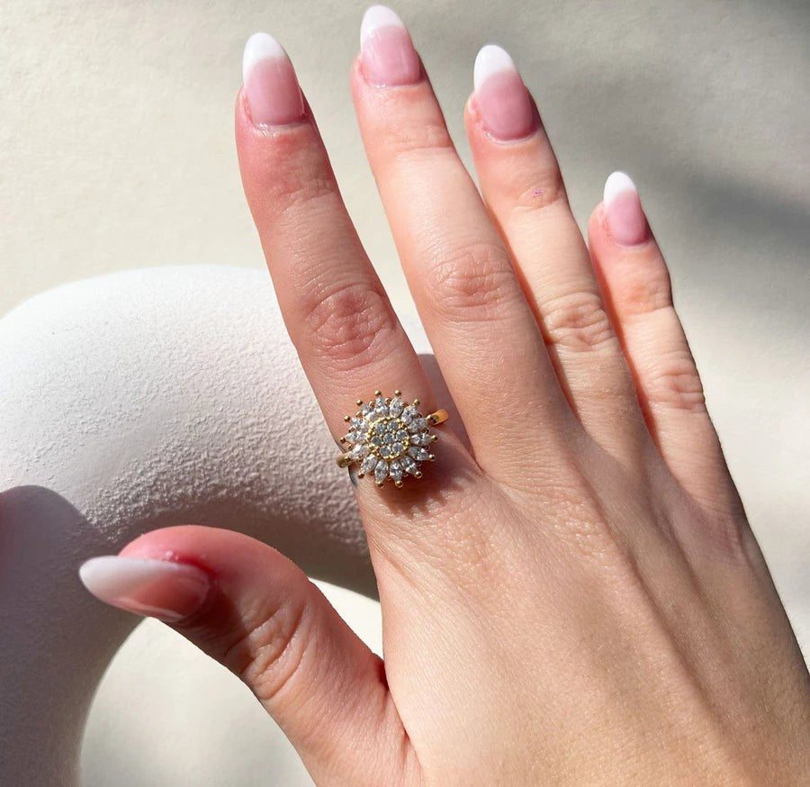 Hand wearing the gold crystal sunflower ring