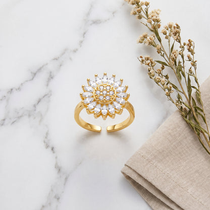 Gold open sunflower spinner ring on white marble